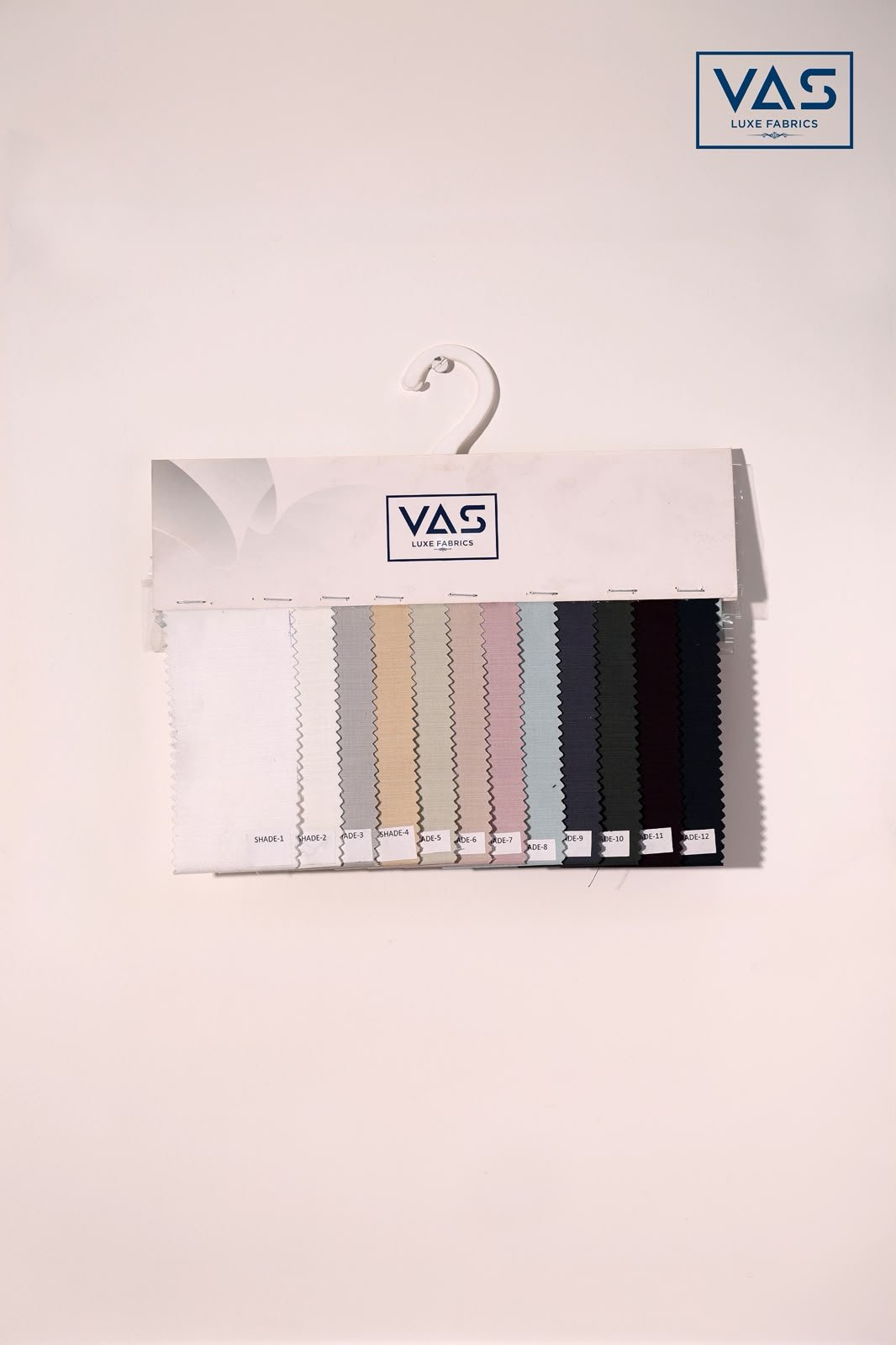 A VAS Luxe Fabrics shade card, twelve numbered shades on a hanger