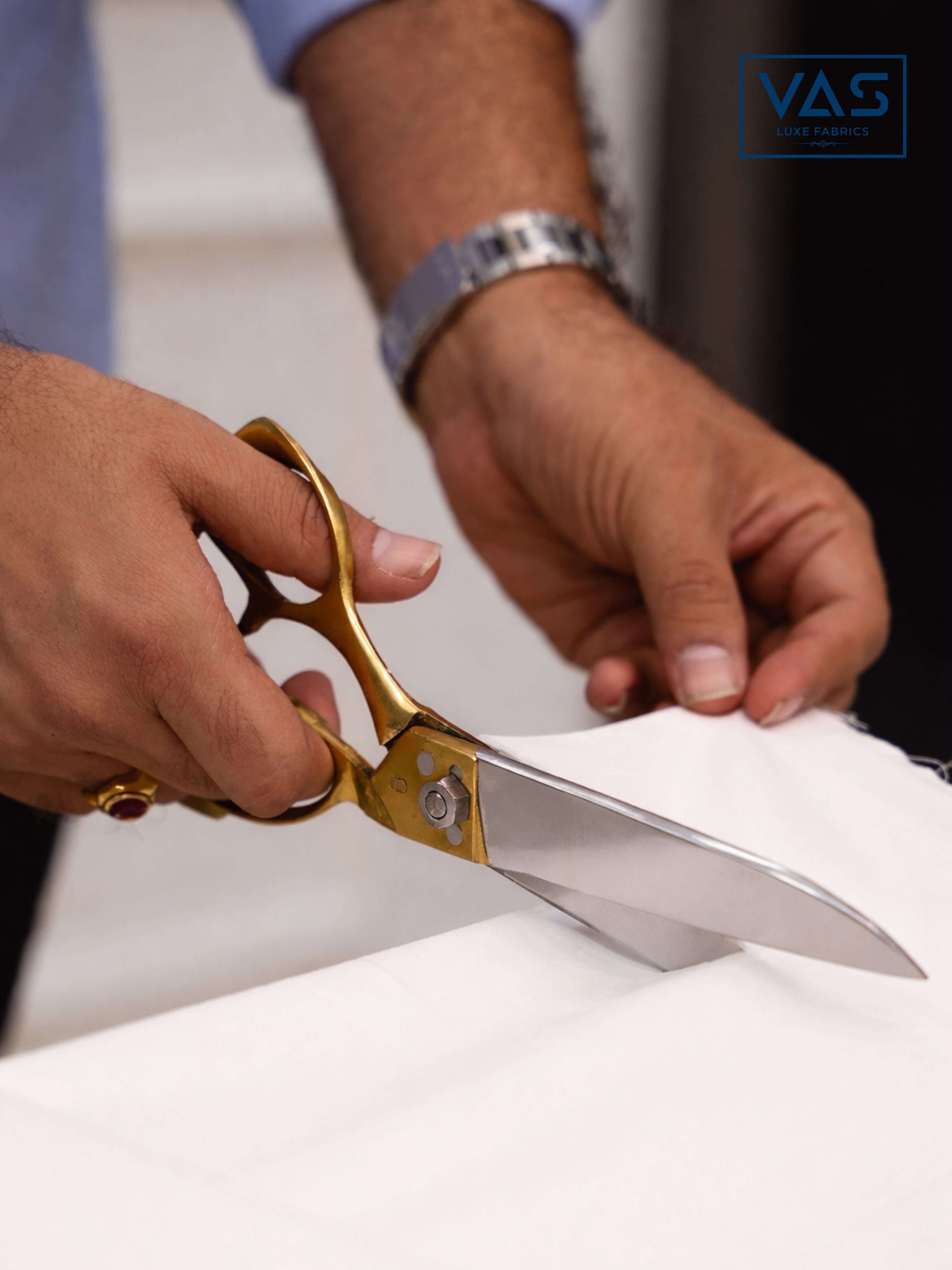 Hands cutting VAS shirting fabric with tailor shears
